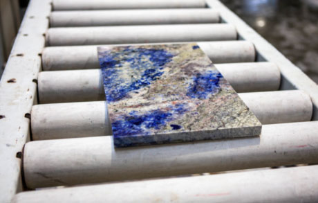 eine kleinere Lapislazuliplatte auf dem Förderband der Schneideanlage in der Werkshalle bei Dinger Stone